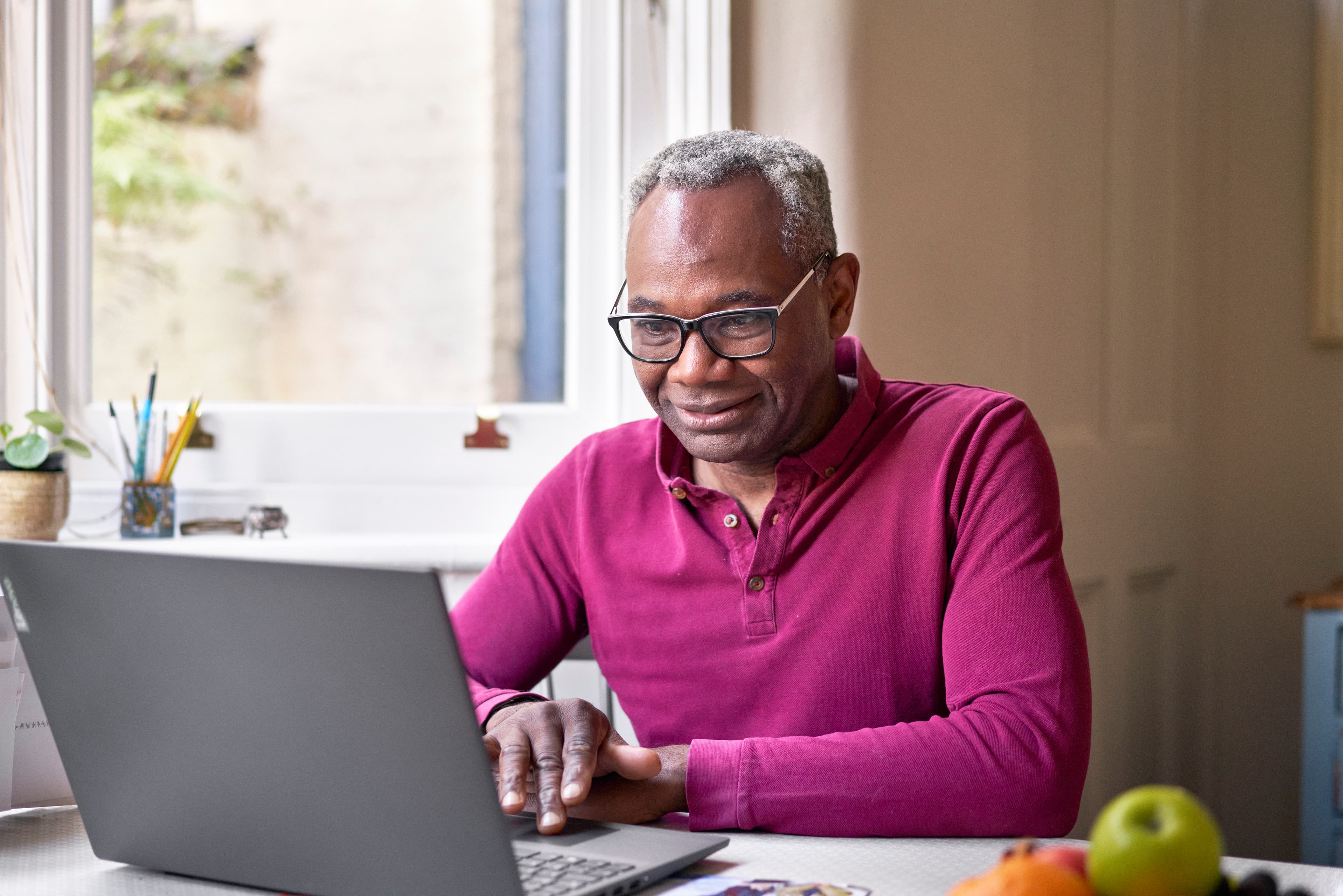 Photo of a man looking at a laptop.